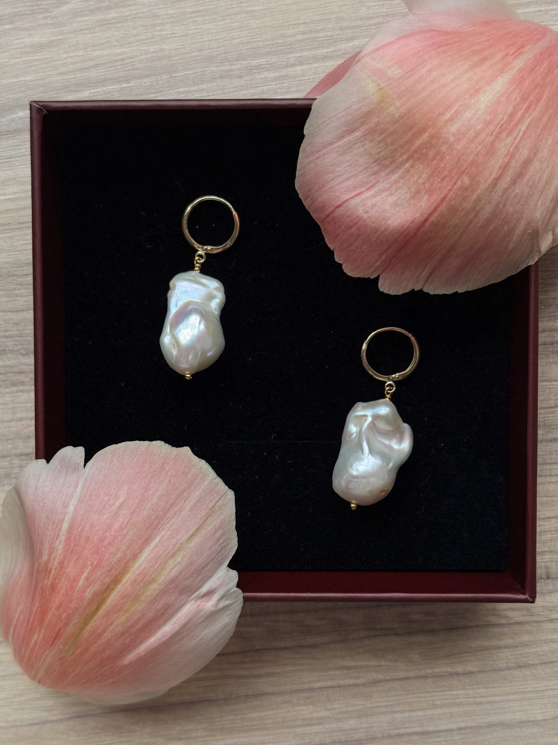 Close-up of high-lustre baroque pearls with gold-filled hoops