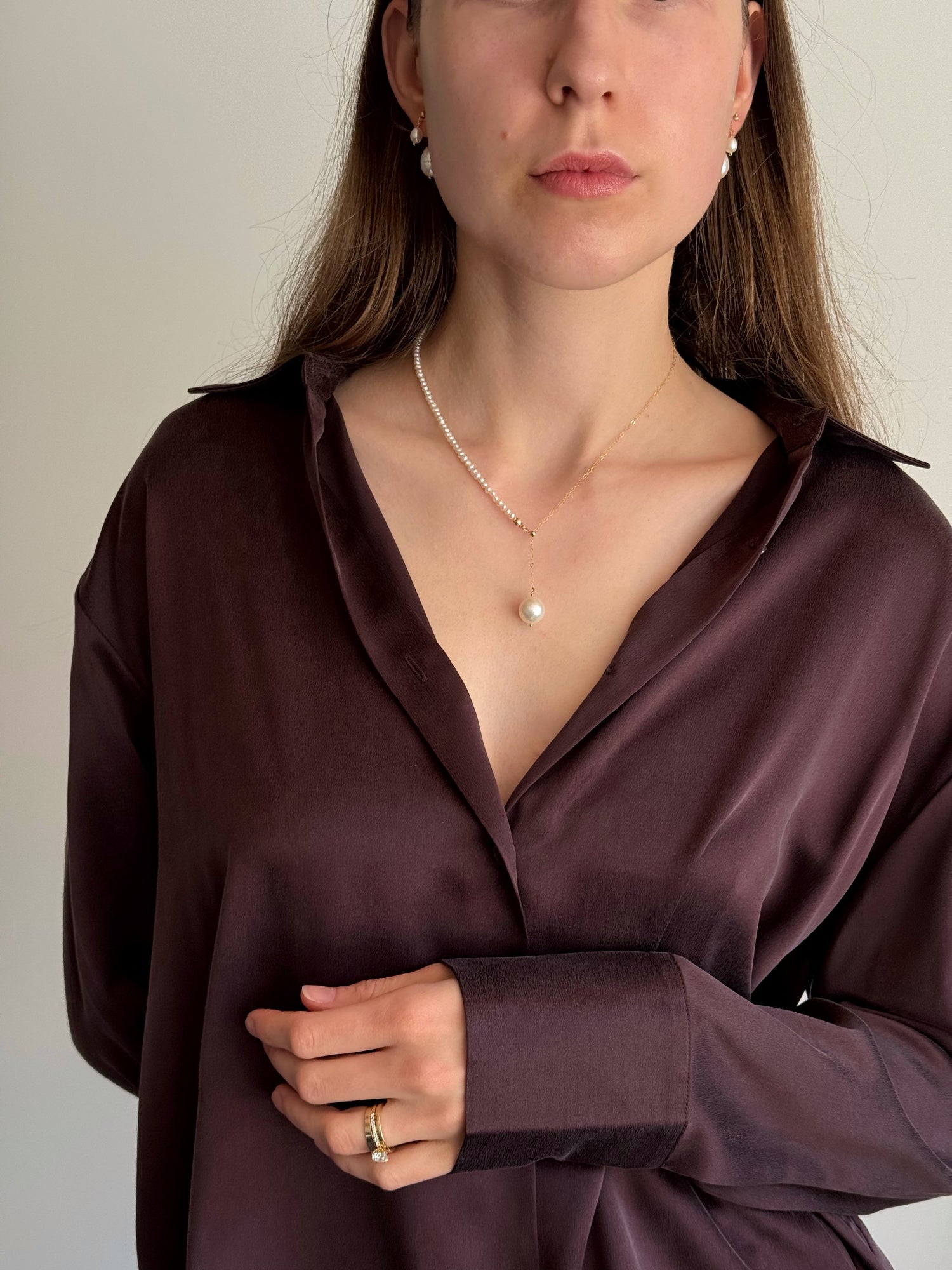 Model wearing asymmetric seed pearl and chain necklace