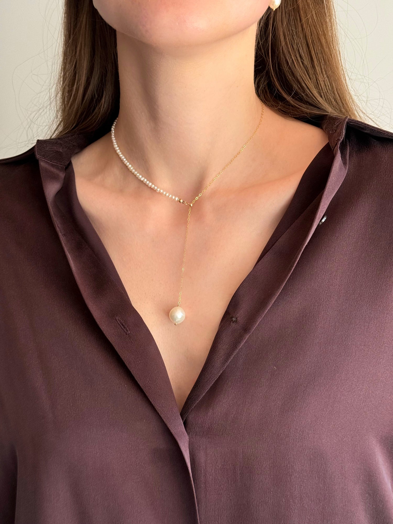 Model wearing asymmetric seed pearl and chain necklace