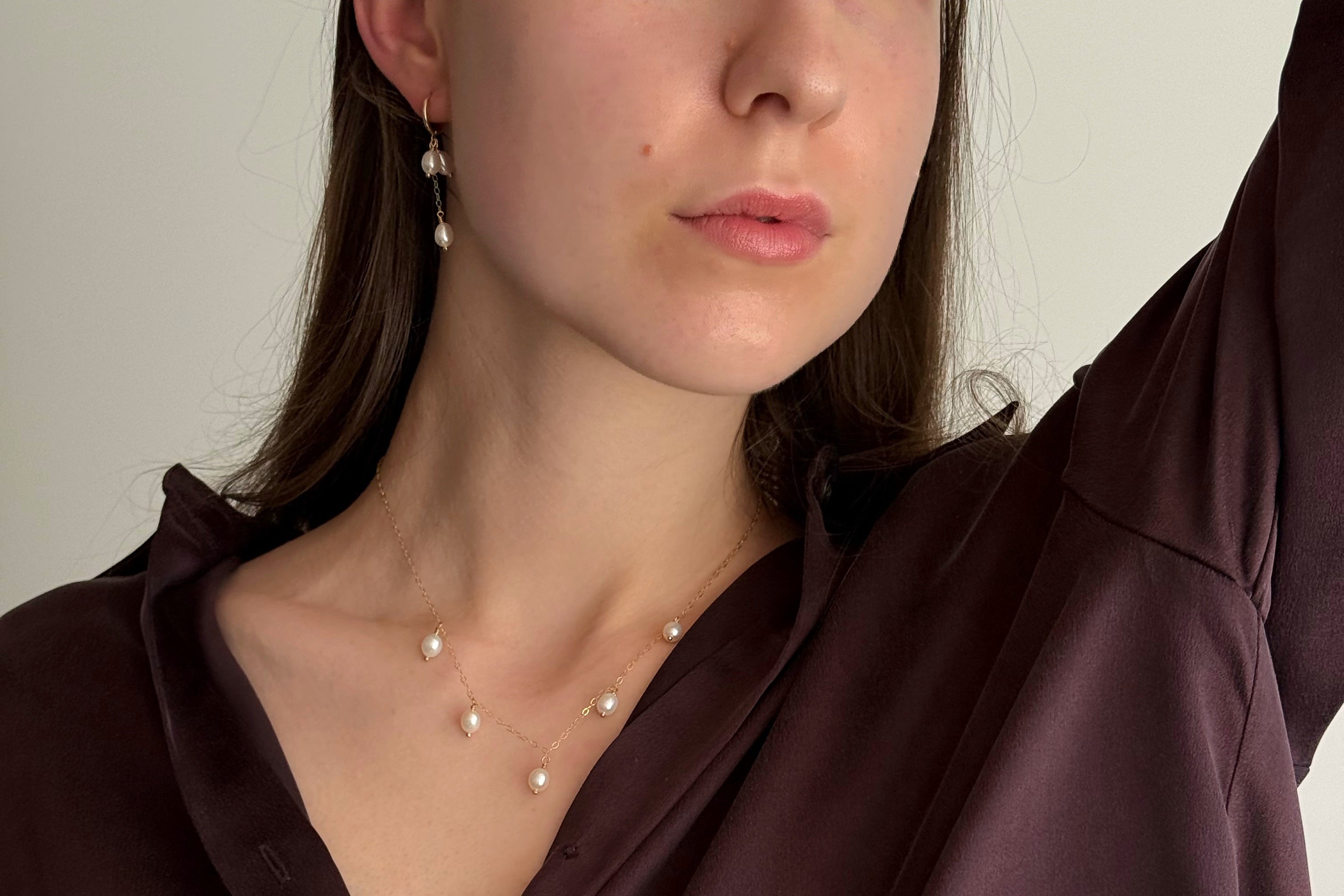Woman wearing handcrafted gold-filled pearl necklace and pearl earrings