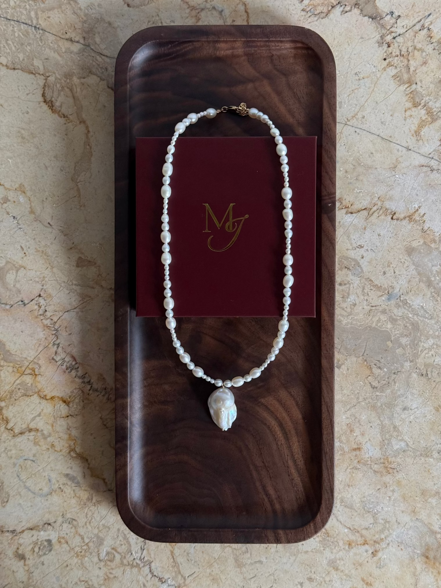 A graduated freshwater pearl necklace with a sculptural baroque pendant. 14k gold-filled findings, made to order in Wellington, New Zealand.