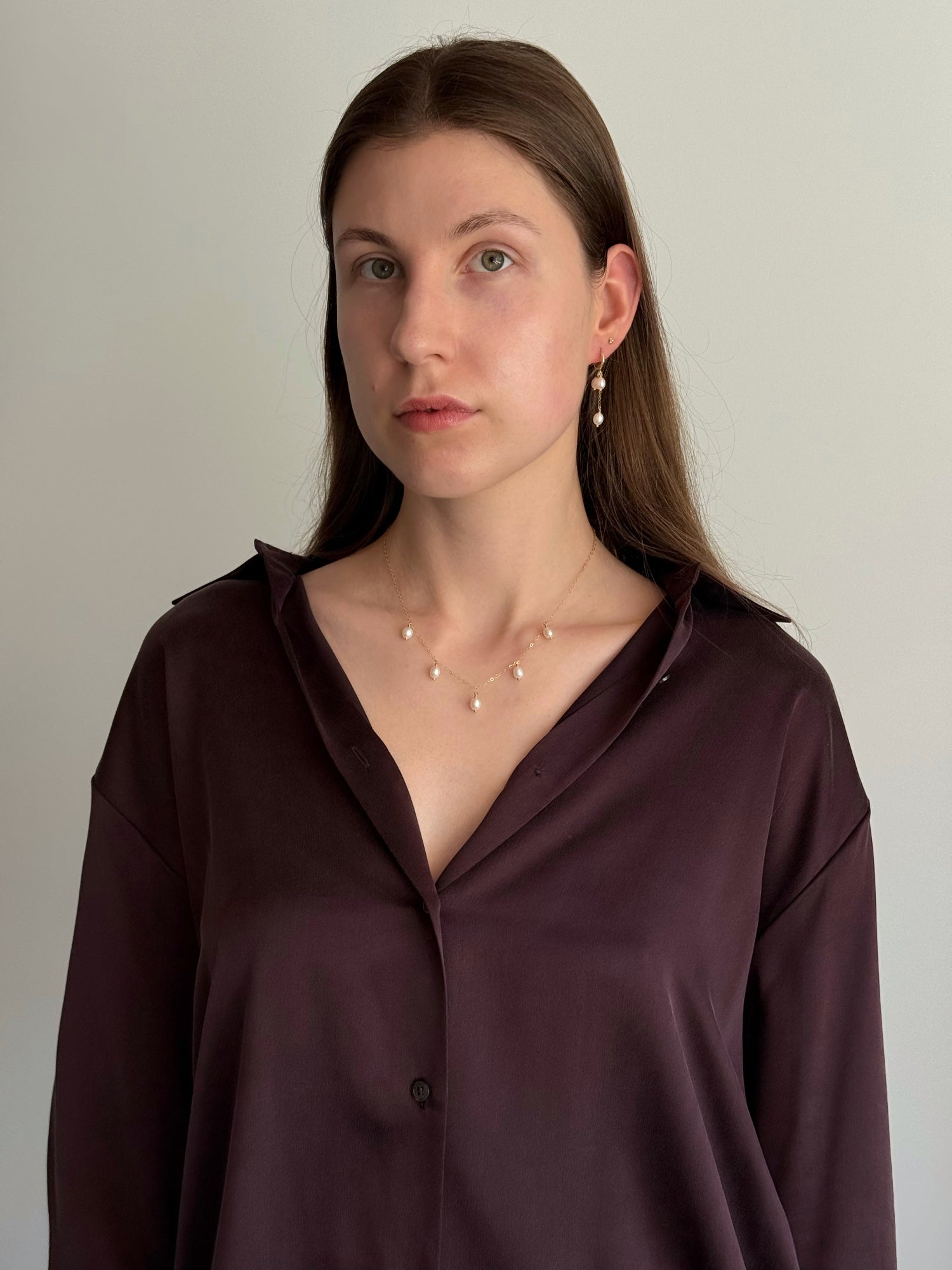 Model wearing pearl drop hoop earrings And pearl necklace