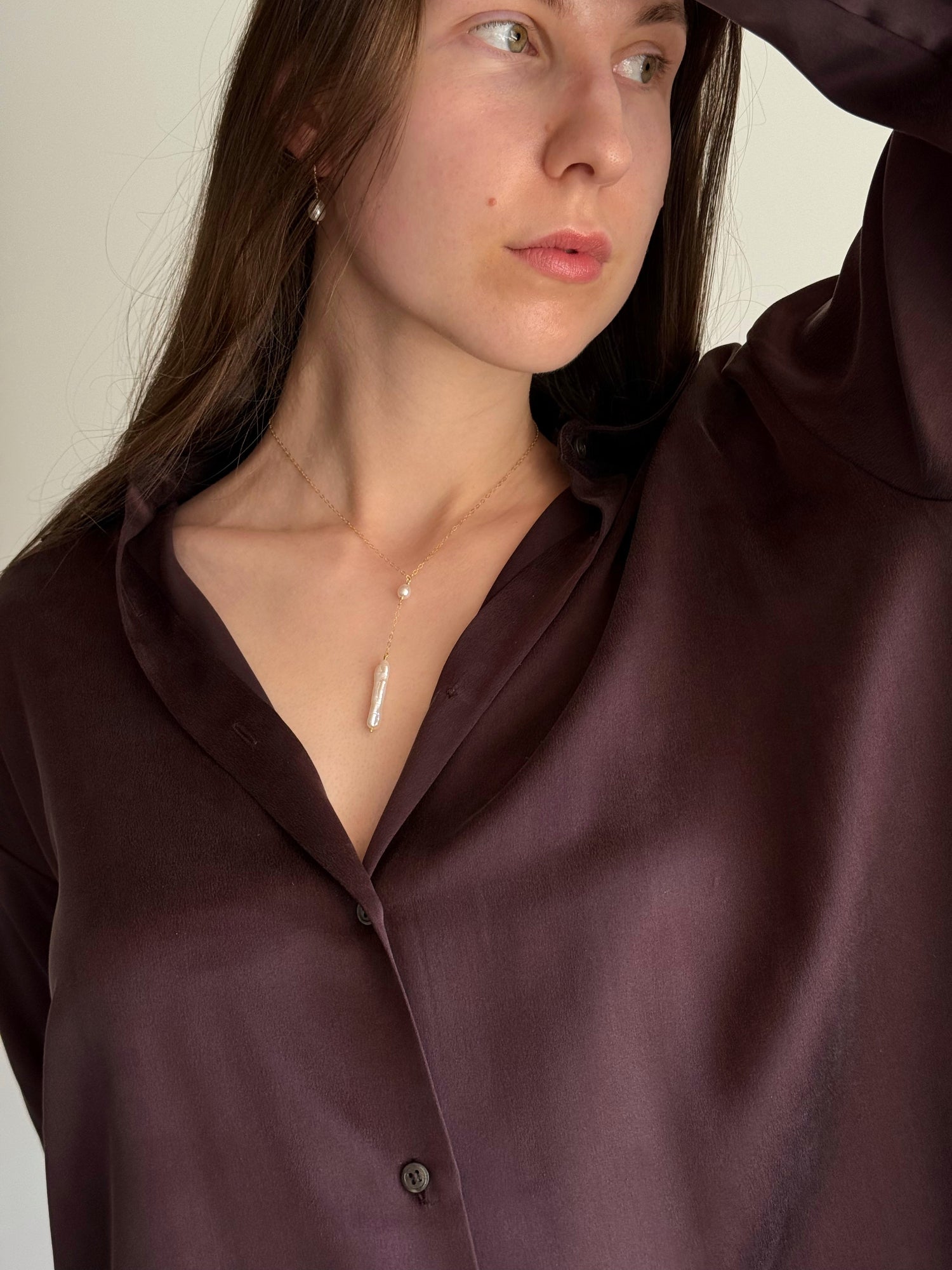 Minimalist pearl drop necklace styled on model