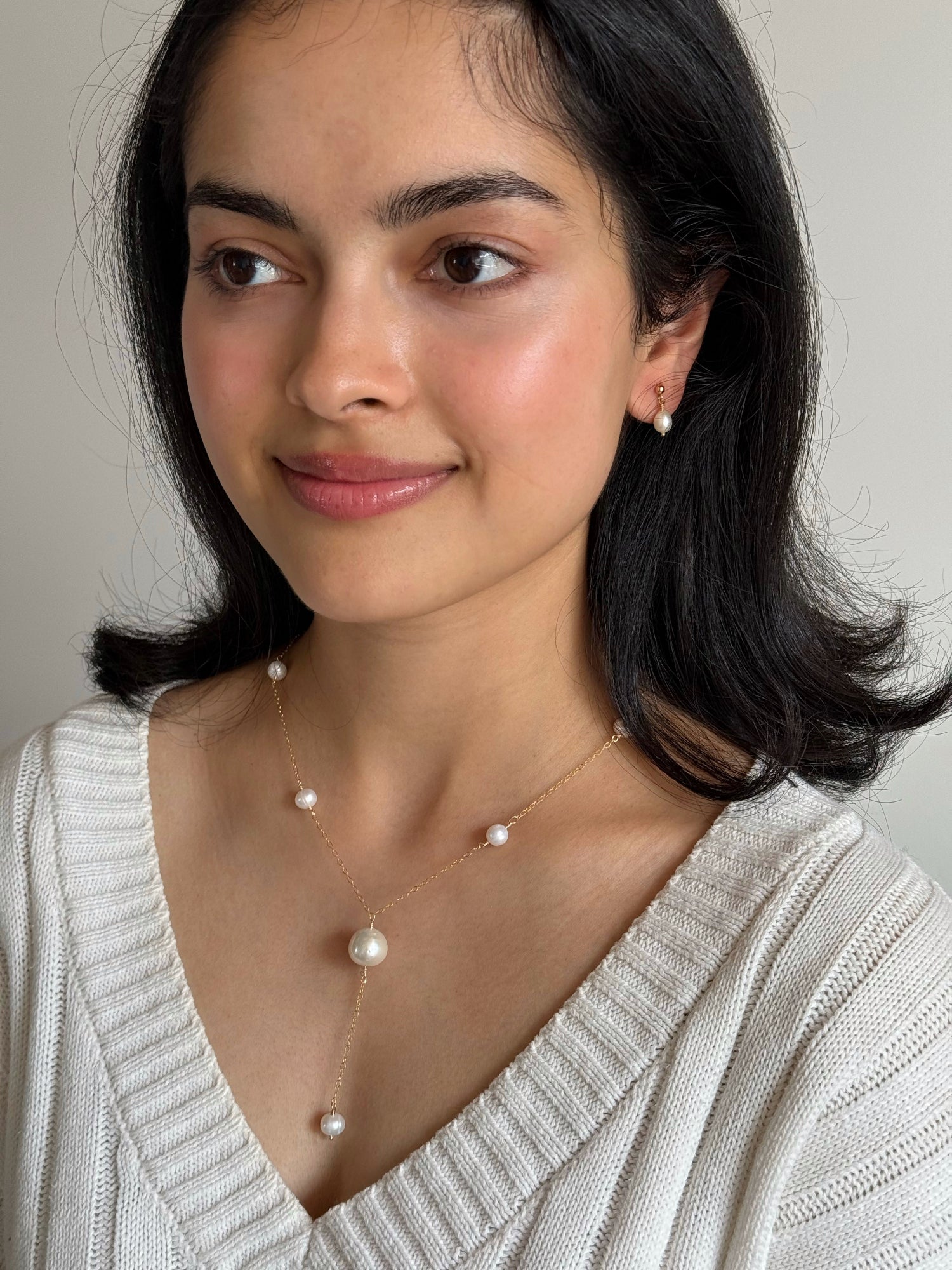 Everyday pearl studs styled with neutral clothing for a clean minimalist look