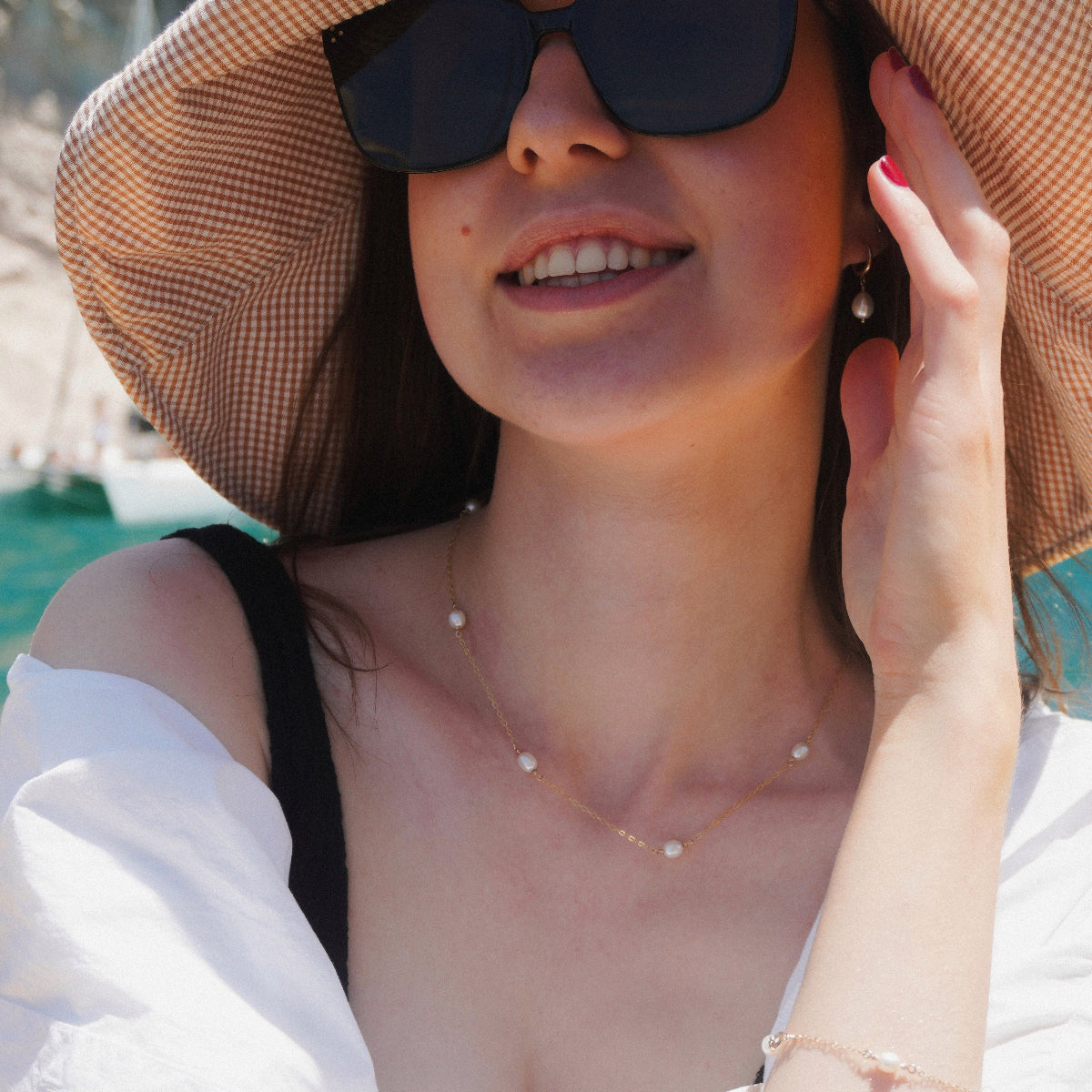 Woman wearing handmade pearl and gold-filled pearl earrings and necklace